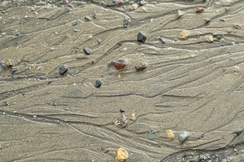 Channels carved by salt water on sand with small stones nearby